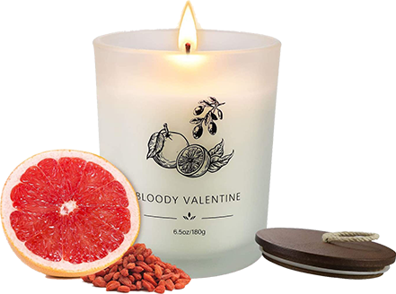 Vela aromática Bloody Valentine em recipiente de vidro fosco com chama acesa, acompanhada por meia toranja, frutas goji berry e tampa de madeira.