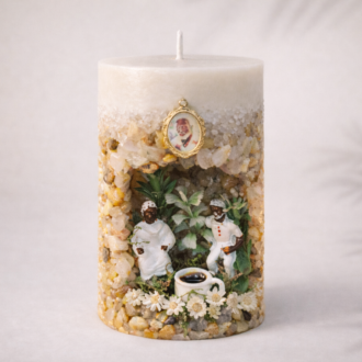 Vela artesanal Gruta dos Pretos Velhos com pedras naturais, miniaturas de Pretos Velhos, flores delicadas e xícara de café em composição espiritual.