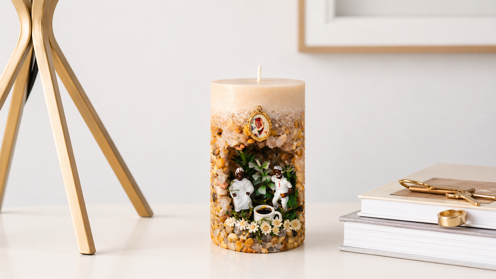 Vela Gruta dos Pretos Velhos artesanal com miniaturas religiosas, pedras decorativas e flores em recipiente decorativo.