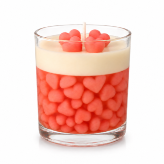Vela aromática decorativa em recipiente de vidro transparente preenchido com delicados corações rosas, finalizada com camada cremosa de cera e detalhes em formato de coração na superfície.
