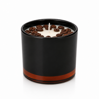 Vela Aromática de Café Torrado em recipiente preto fosco com detalhe âmbar na base, preenchida com cera clara e decorada com grãos de café ao redor do pavio central. A imagem apresenta fundo branco limpo, destacando o design sofisticado e contemporâneo do produto.