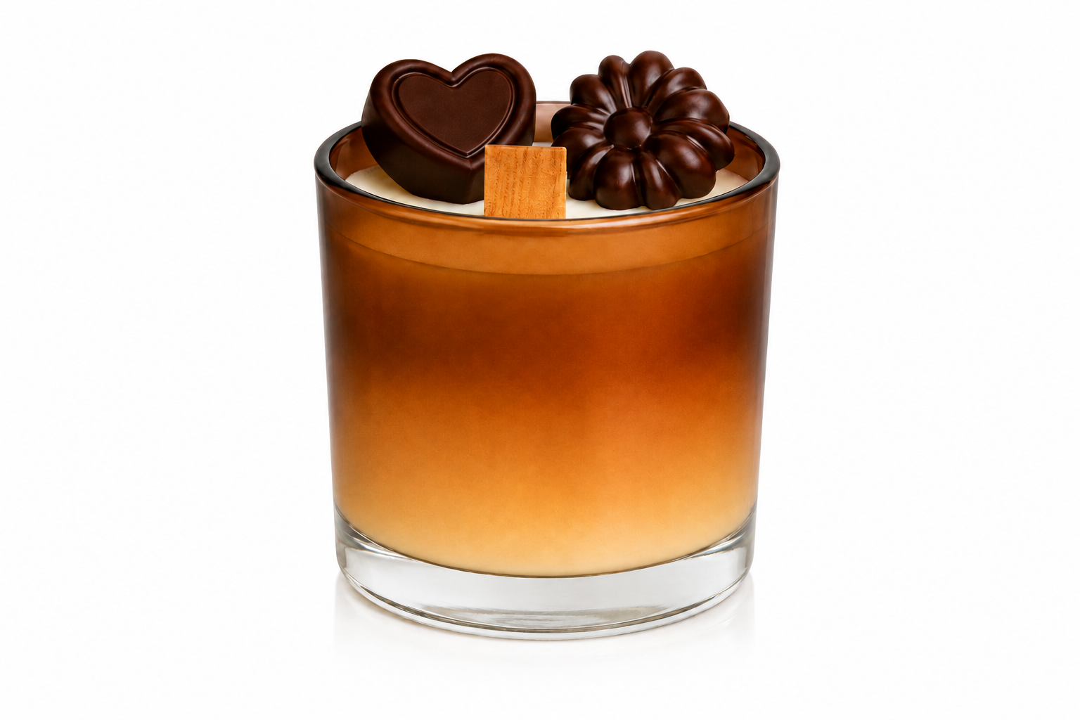 Vela Aromática de Chocolate em copo de vidro degradê nos tons de creme e chocolate, decorada com miniaturas de chocolates em formato de coração e flor sobre a superfície. A peça possui pavio de madeira e acabamento sofisticado, apresentada em fundo branco com iluminação suave para destaque dos detalhes artesanais.
