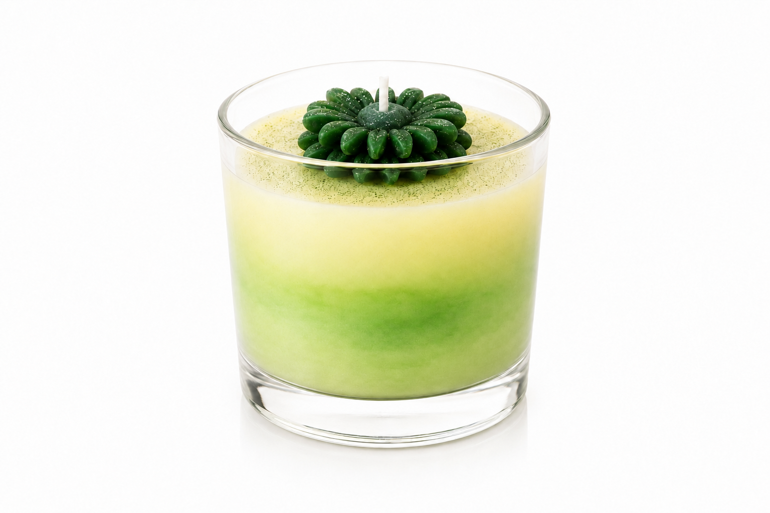 Vela Aromática Flower Green em copo de vidro transparente, com elegante efeito marmorizado em tons suaves de verde e creme. A peça é decorada com uma delicada flor verde esculpida em cera no topo e apresenta acabamento artesanal sofisticado, destacando sua inspiração botânica e natural.