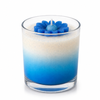 Vela aromática em vidro transparente com degradê em tons de azul e branco, decorada com uma margarida azul esculpida em cera, apresentada sobre fundo branco em estilo e-commerce, destacando seus detalhes artesanais e acabamento sofisticado.