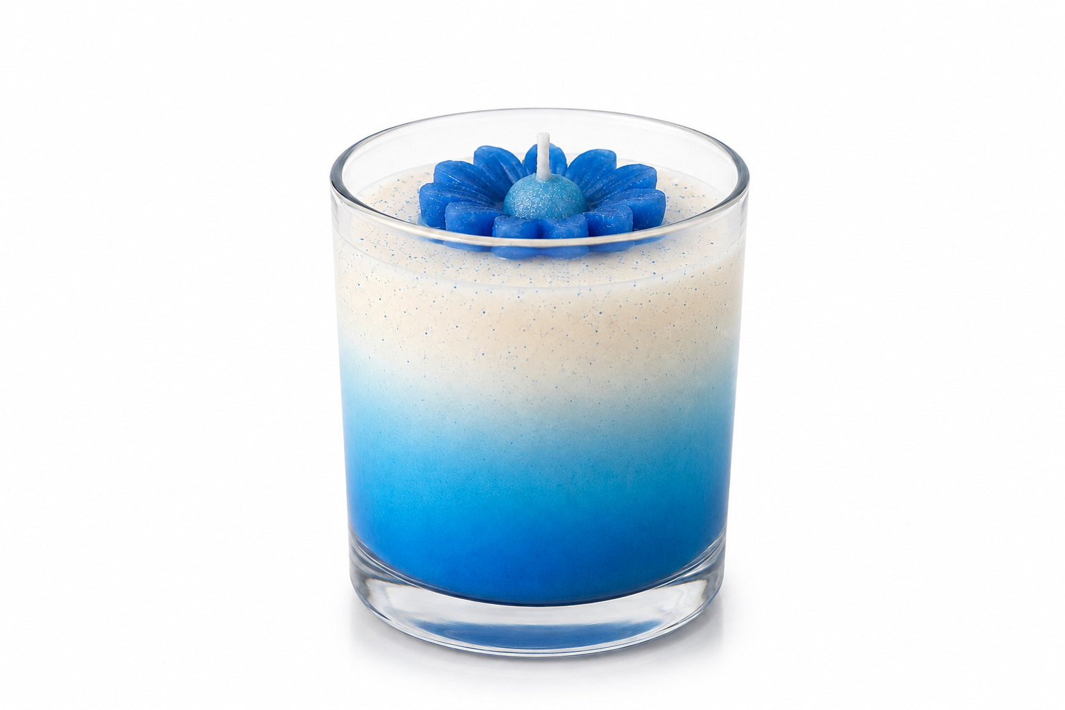 Vela aromática em vidro transparente com degradê em tons de azul e branco, decorada com uma margarida azul esculpida em cera, apresentada sobre fundo branco em estilo e-commerce, destacando seus detalhes artesanais e acabamento sofisticado.