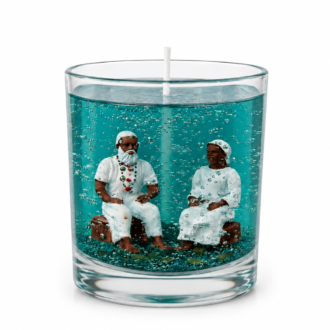 Vela em gel azul com miniaturas artesanais de um casal de Pretos Velhos em seu interior, apresentada em fundo branco minimalista que destaca a transparência do gel e os detalhes da composição espiritual.