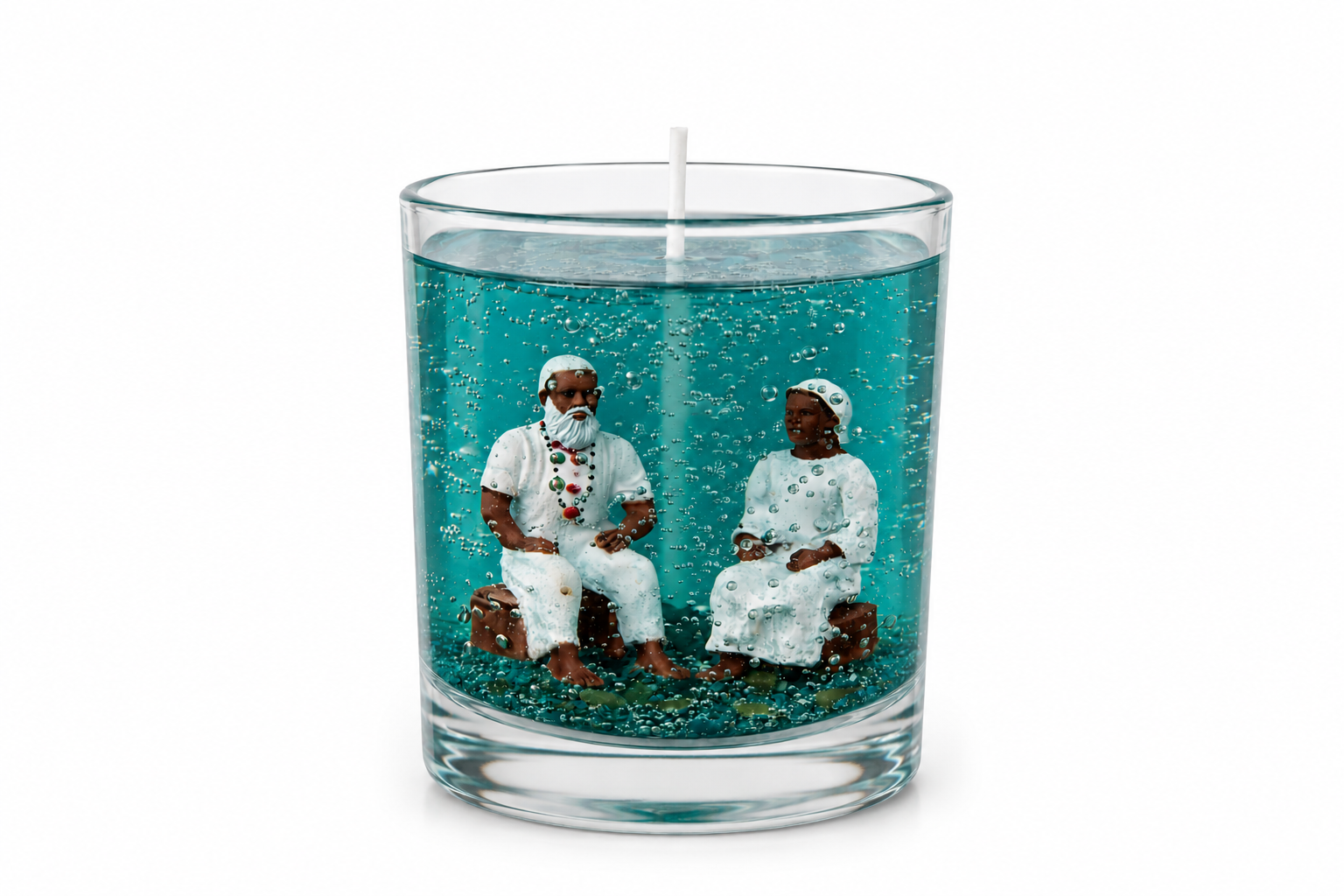 Vela em gel azul com miniaturas artesanais de um casal de Pretos Velhos em seu interior, apresentada em fundo branco minimalista que destaca a transparência do gel e os detalhes da composição espiritual.