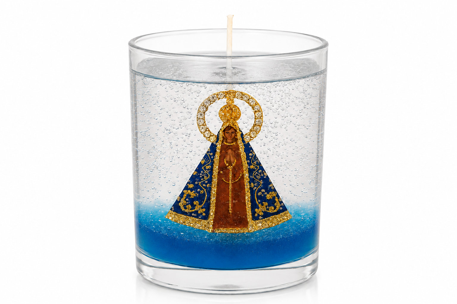 Vela em Gel Nossa Senhora Aparecida artesanal em copo de vidro transparente, com imagem da Padroeira do Brasil ao centro, envolvida por parafina em gel cristalina repleta de delicadas bolhas decorativas. A peça possui uma elegante base azul que destaca a imagem religiosa e cria um belo contraste com os detalhes dourados do manto e da coroa. Fotografada em fundo branco, a vela evidencia sua transparência, sofisticação e acabamento artesanal.