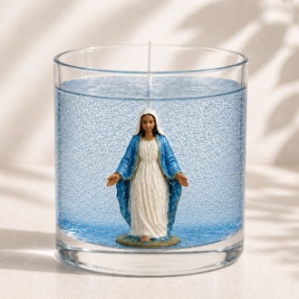Vela em Gel Nossa Senhora das Graças artesanal em recipiente de vidro transparente com gel azul, contendo a imagem de Nossa Senhora das Graças em seu interior, fotografada sobre fundo claro com sombras suaves de folhas em estilo minimalista e elegante.