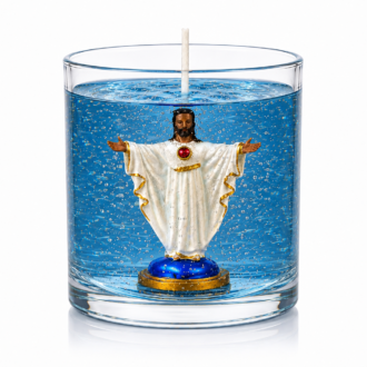 Vela em gel azul transparente com microbolhas decorativas em recipiente cilíndrico de vidro. No interior encontra-se uma imagem do Sagrado Coração de Jesus com vestes brancas, detalhes dourados, coração vermelho destacado no peito e braços abertos em gesto de acolhimento. A peça está fotografada sobre fundo branco, evidenciando os detalhes artesanais, a transparência do gel e a temática religiosa da vela.
