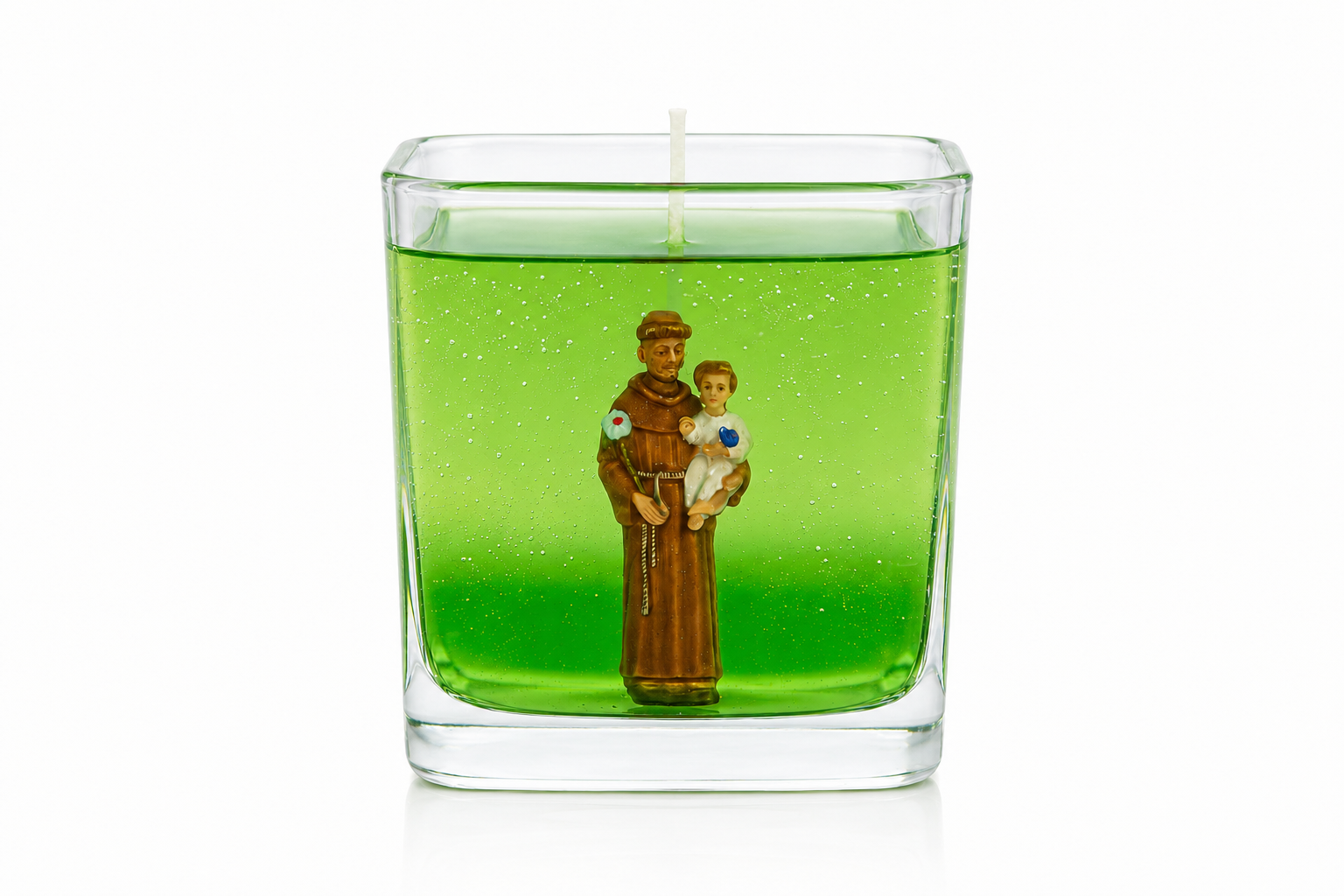 Vela em gel verde transparente com imagem de Santo Antônio segurando o Menino Jesus, acondicionada em recipiente quadrado de vidro. A peça apresenta design elegante e minimalista, destacando a figura religiosa em meio ao gel translúcido, transmitindo uma atmosfera de fé, proteção e serenidade.
