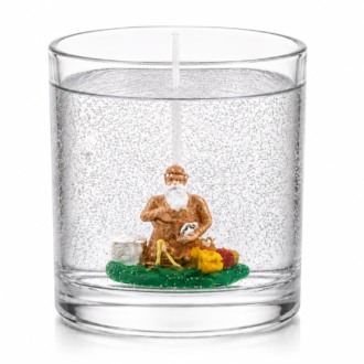 Vela em Gel Xangô artesanal em copo de vidro transparente, com figura decorativa de Xangô em seu interior, fotografada sobre fundo branco em estilo catálogo, destacando a transparência do gel e os detalhes da composição.