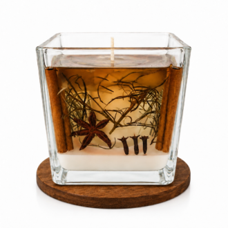 Vela Luminária de Limpeza e Purificação em recipiente quadrado de vidro transparente, com base de cera branca e camada superior de parafina em gel âmbar. A composição interna apresenta canela em pau, anis-estrelado, cravo-da-índia e ervas naturais cuidadosamente distribuídas no interior do gel, criando um visual sofisticado e acolhedor. A vela está posicionada sobre uma base redonda de madeira em fundo branco suave, destacando os detalhes artesanais da peça.