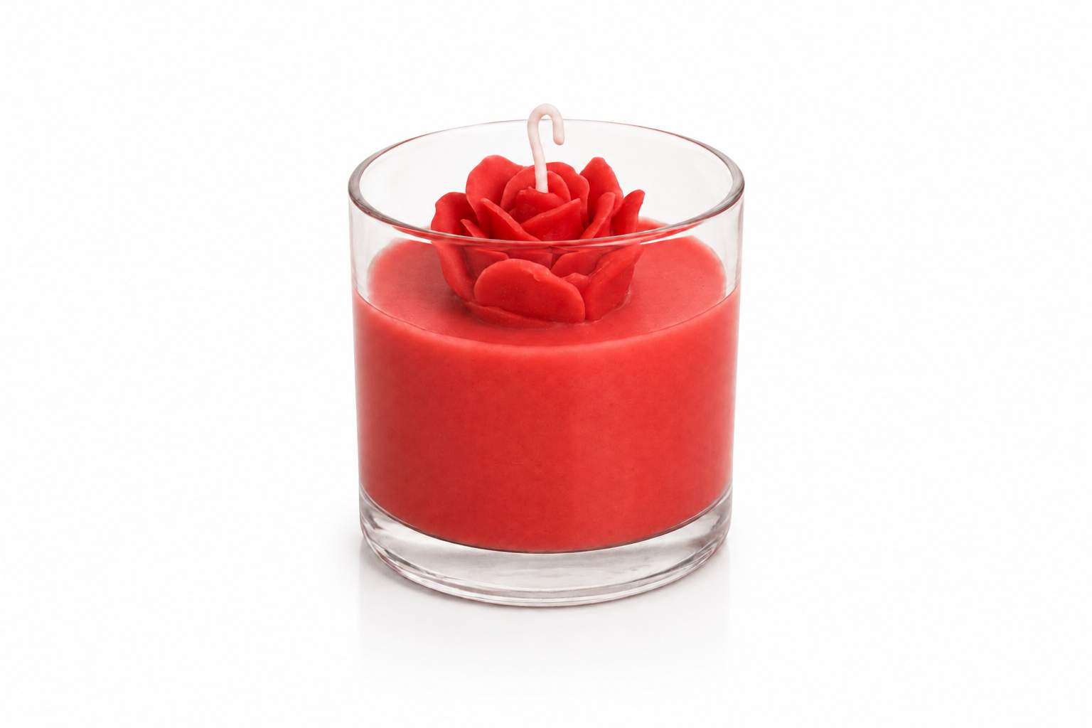 Vela Rosa Vermelha artesanal em copo de vidro transparente, preenchida com cera vermelha vibrante e decorada com uma delicada rosa esculpida em cera no topo. A imagem apresenta fundo branco suave e iluminação limpa, destacando os detalhes da peça com elegância e sofisticação.