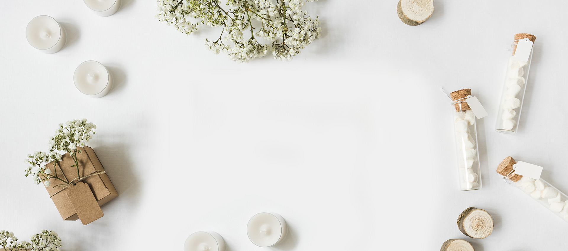 Arranjo decorativo em fundo branco com velas, flores delicadas, embalagens para presente e frascos de vidro, deixando amplo espaço central para texto ou conteúdo.